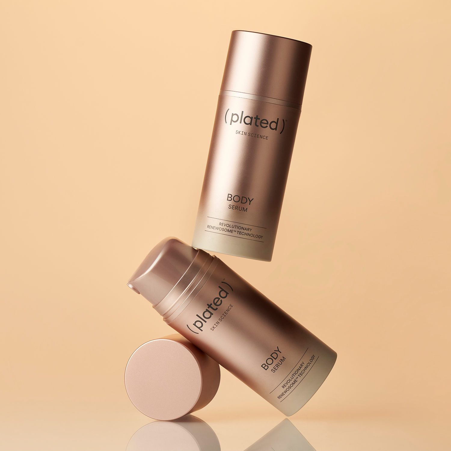 Two ( plated ) Skin Science BODY Serum product bottles on a beige background