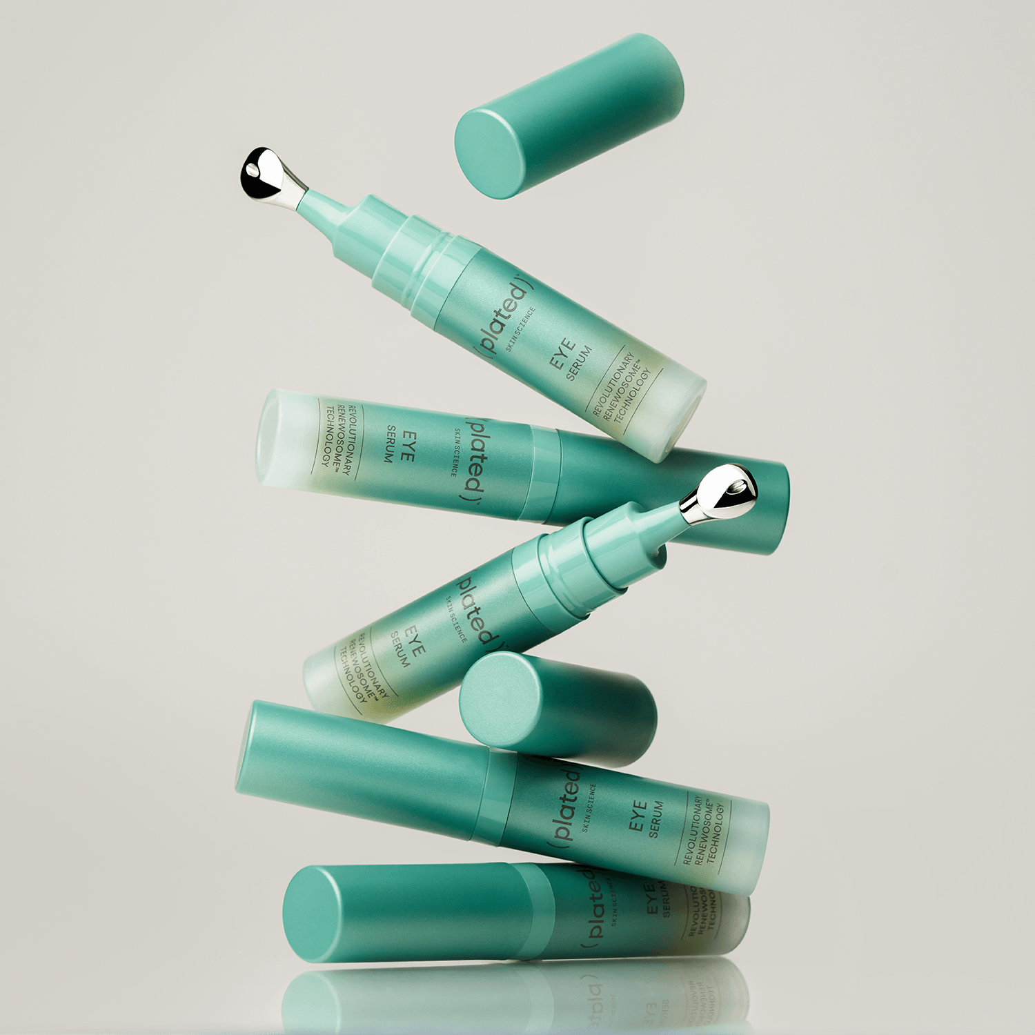 Green ( plated ) EYE Serum bottles on a grey background