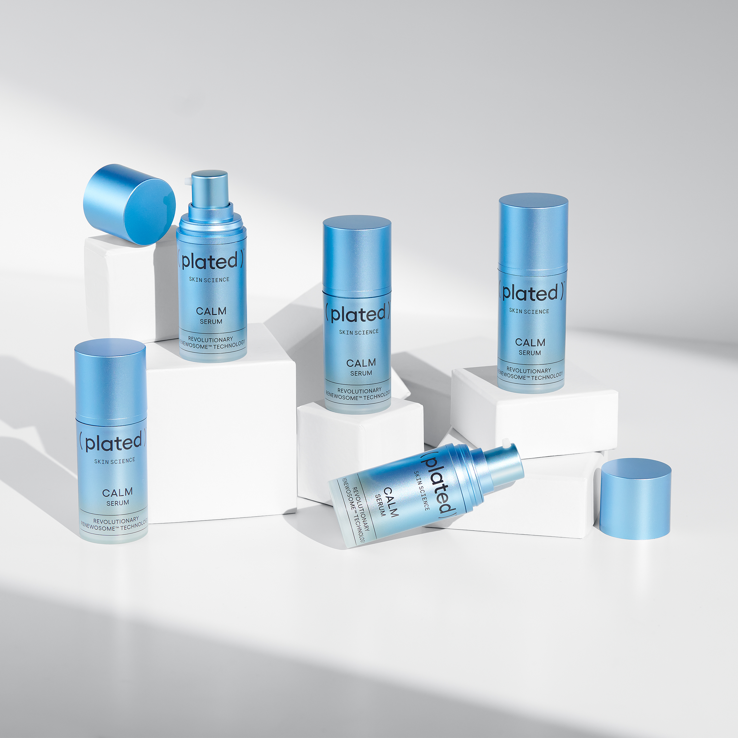 Multiple bottle of ( plated )® Skin Science CALM Serum products on a grey background