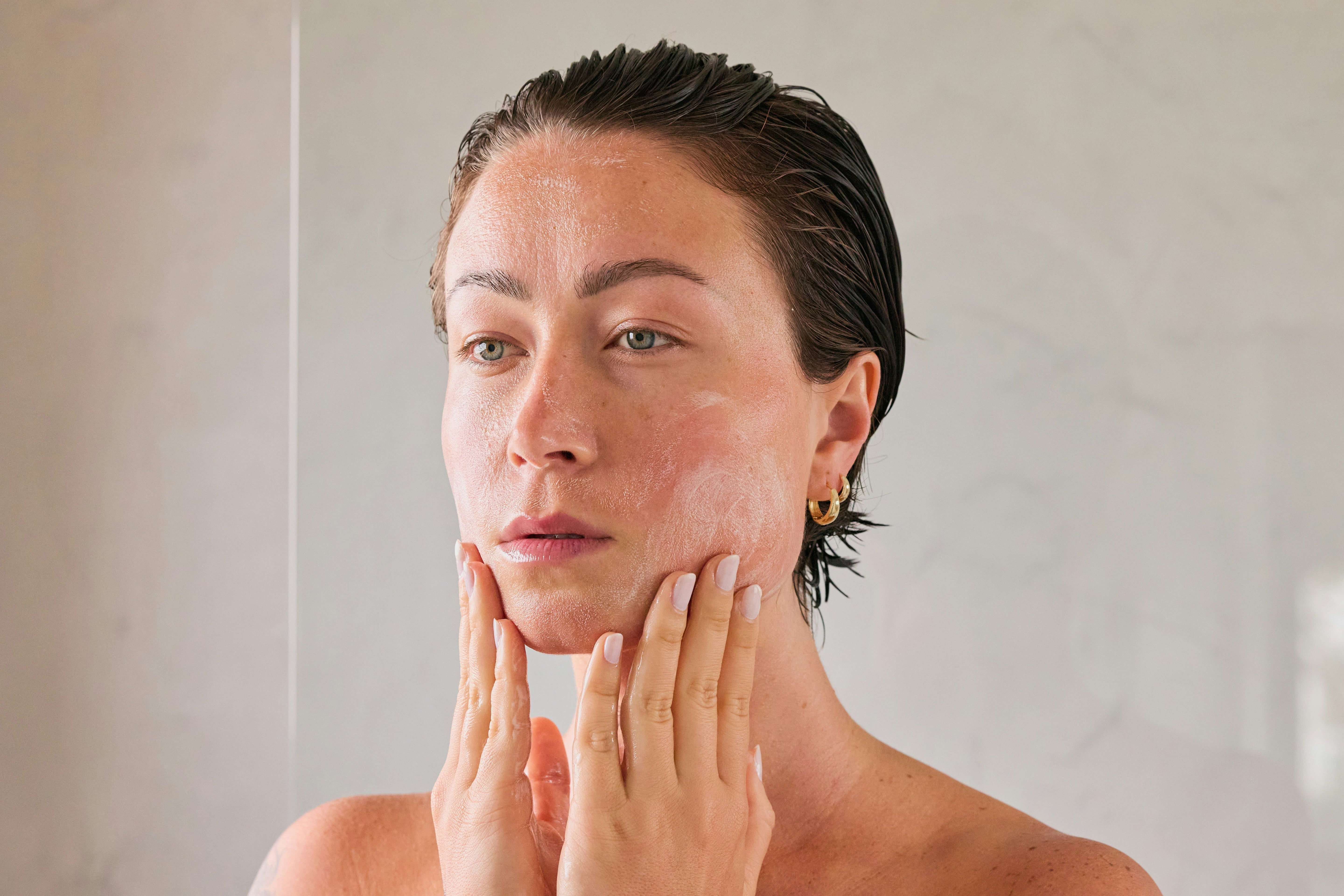 Woman looking at skin in the mirror 