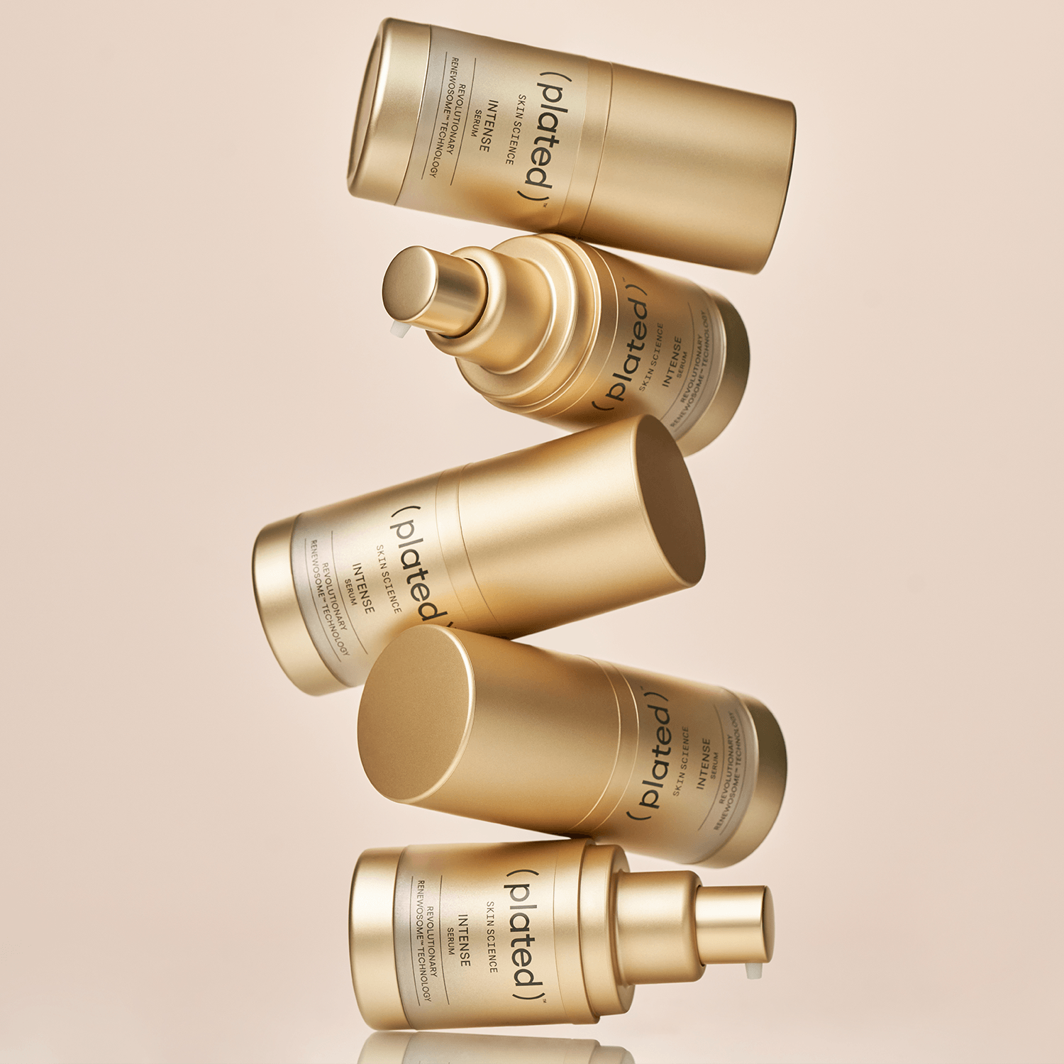 Gold ( plated ) INTENSE skincare bottles on a beige background