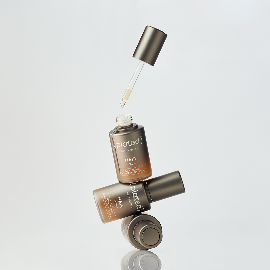 ( plated ) HAIR Serum with dropper bottle on a light gray background
